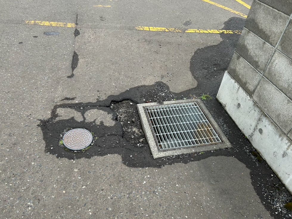 札幌市西区某駐車場のアスファルト補修前（排水溝周り）